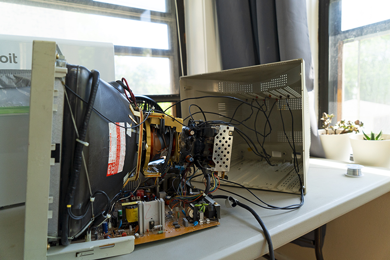 A CRT monitor opened with cables going to four electromagnets placed around the electron gun.