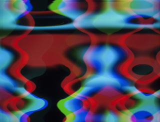 Visuals generated with the RGB.VGA.VOLT video synthesizer; reds and cyans with hints of blue, green, and other colors appear in